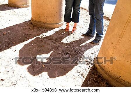 Stock Image - Shadow of a couple kissing in the sun. Fotosearch