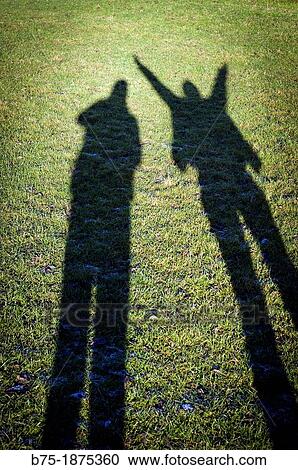Shadow of two people in the field View Large Photo Image Stock Image - Shadow of two people in the field. Fotosearch
