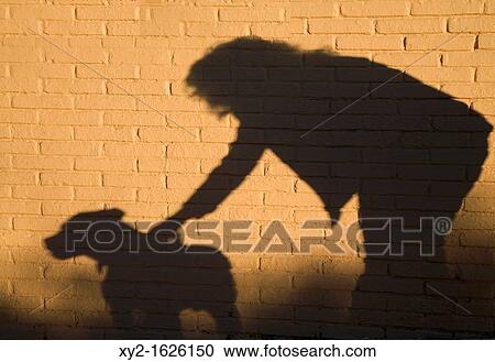 Shadow of woman and dog against brick wall View Large Photo Image Stock Image - Shadow of woman and dog against brick wall. Fotosearch
