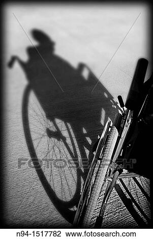 Stock Image - Shadow on the floor of an old woman sitting in her wheelchair.. Fotosearch