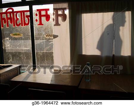 Stock Image - Shadows of people scene from inside an eatery in Patan, Nepal.. Fotosearch