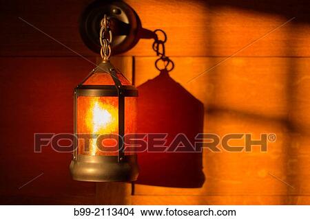 Picture - SHADOWS OF WINDOW AND SCONCE LANTERN ON WOOD PANELED WALL OF AMERICAN ARTS AND CRAFTS STYLE HOME.. Fotosearch