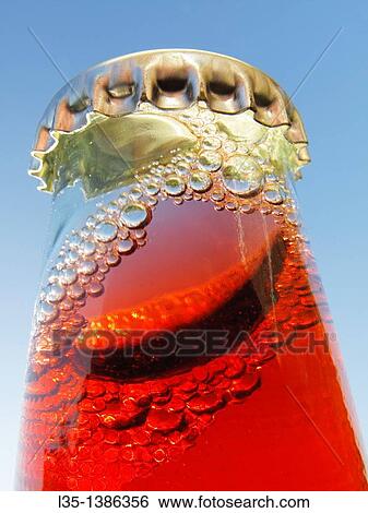 Stock Photograph - Shaken bottle neck with crown cap and a red liquid and many bubbles. Fotosearch