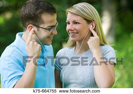 Stock Photography - Sharig mp 3 player to listen to music. Fotosearch