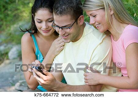 Sharing a handheld wireless device View Large Photo Image Stock Image - Sharing a handheld wireless device. Fotosearch