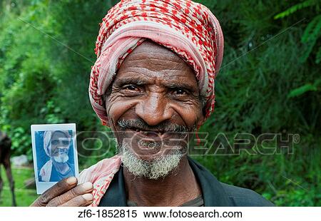 Shashemene Ethiopia Africa Alaba tribe portrait of local old man with red turban farmer proud of Fuji Polaroid of himself 9 View Large Photo Image Stock Photography - Shashemene Ethiopia Africa Alaba tribe portrait of local old man with red turban farmer proud of Fuji Polaroid of himself 9. Fotosearch