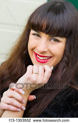 Stock Image - She is engaged now, showing her finger engagement ring. Fotosearch