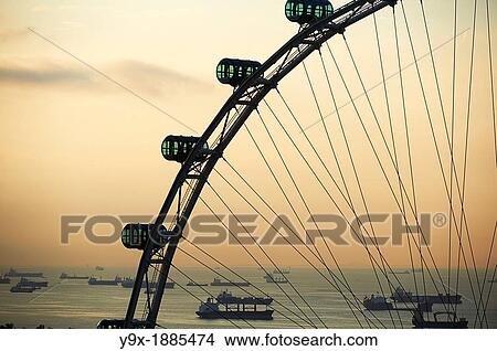 Shipping boats and freighters at sunset off the coast of Singapore as seen through the Singapore Flyer View Large Photo Image Picture - Shipping boats and freighters at sunset off the coast of Singapore as seen through the Singapore Flyer. Fotosearch