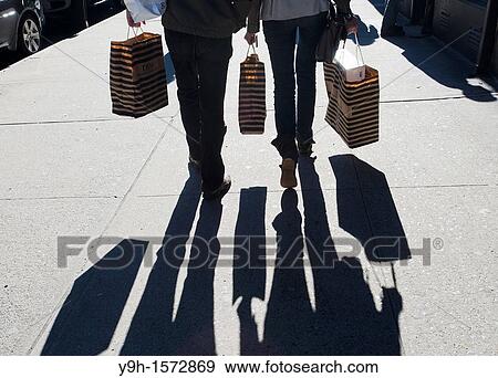 Shoppers with their purchases in Greenwich Village in New York View Large Photo Image Stock Photo - Shoppers with their purchases in Greenwich Village in New York. Fotosearch