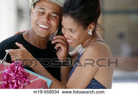 shopping couple listening on cell phone View Large Photo Image Picture - shopping couple listening on cell phone. Fotosearch