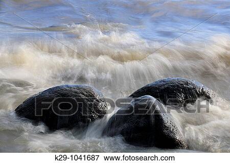 Stock Photo - Shoreline rocks and crashing waves along shore of Lake Winnipeg. Fotosearch