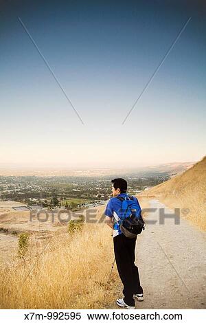 Shortly after sunrise, a male Korean hiker looks down at the view of the city of Fremont and Ohlone College from the Peak Trail at Mission Peak Regional Preserve in Fremont, California View Large Photo Image Stock Photography - Shortly after sunrise, a male Korean hiker looks down at the view of the city of Fremont and Ohlone College from the Peak Trail at Mission Peak Regional Preserve in Fremont, California. Fotosearch