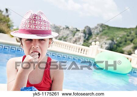 Shot of a Cute Child in Pink Eating a Snack beside the pool View Large Photo Image Stock Image - Shot of a Cute Child in Pink Eating a Snack beside the pool. Fotosearch