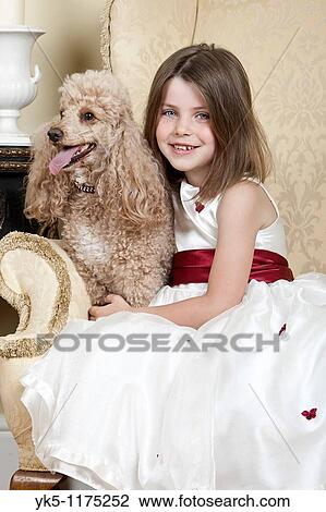 Shot of a Happy Blonde Girl in Large Armchair with an Apricot French Miniature Poodle View Large Photo Image Stock Image - Shot of a Happy Blonde Girl in Large Armchair with an Apricot French Miniature Poodle. Fotosearch