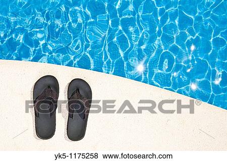 Shot of a Pair of Flip Flops next to the Pool View Large Photo Image Stock Photo - Shot of a Pair of Flip Flops next to the Pool. Fotosearch