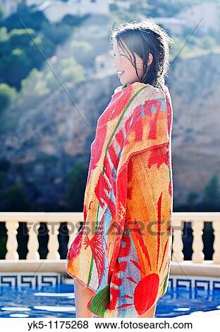 Stock Photo - Shot of a Pretty Brown Haired Child with Towel Wrapped around Her Next to Swimming Pool. Fotosearch