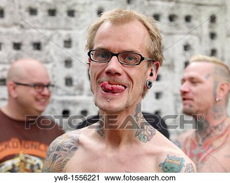 Stock Image - Showing off spilt tongue piercing and Tattoos, Reykjavik, Iceland. Fotosearch