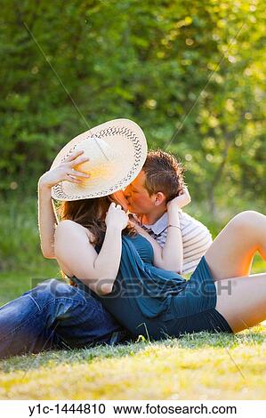 Shy young couple kissing on the grass View Large Photo Image Stock Image - Shy young couple kissing on the grass. Fotosearch