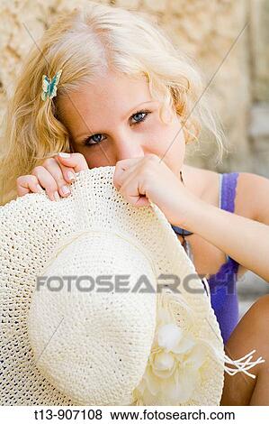 Shy young woman hiding behind White hat View Large Photo Image Stock Photo - Shy young woman hiding behind White hat. Fotosearch