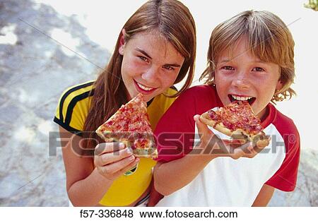 Siblings eating pizza View Large Photo Image Stock Photo - Siblings eating pizza. Fotosearch