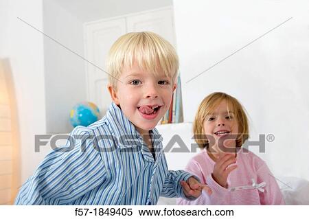 Siblings playing on their bed View Large Photo Image Stock Photography - Siblings playing on their bed. Fotosearch