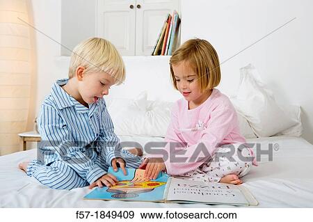 Siblings reading a book in their pyjamas View Large Photo Image Stock Photo - Siblings reading a book in their pyjamas. Fotosearch