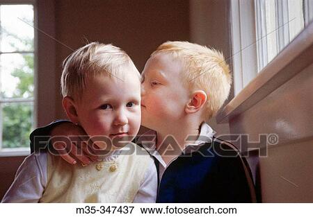 Stock Photo - Siblings telling secrets. Fotosearch