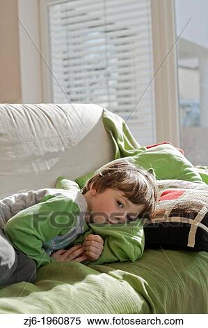Stock Photography - Sick boy lying on sofa.. Fotosearch