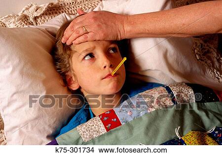 Picture - sick in bed with a temperature. Fotosearch