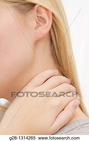 Side view of young woman holding her neck with her hand dressed in grey detail, for neck pain View Large Photo Image Stock Photography - Side view of young woman holding her neck with her hand dressed in grey detail, for neck pain. Fotosearch