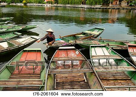sightseeing boats docked on the Tam Coc River in Ninh Binh, Vietnam. View Large Photo Image Picture - sightseeing boats docked on the Tam Coc River in Ninh Binh, Vietnam.. Fotosearch