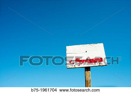 sign with an arrow with a blue sky in the background View Large Photo Image Picture - sign with an arrow with a blue sky in the background. Fotosearch
