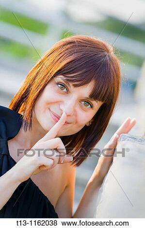 Stock Photo - Silence please happy young woman portrait. Fotosearch