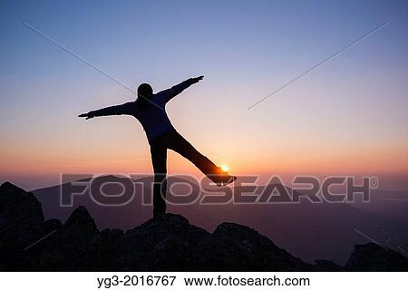 Silhouette as female hiker balances on rock viewing mountain sunset from summit of Glyder Fach, Snowdonia national park, Wales. View Large Photo Image Stock Photo - Silhouette as female hiker balances on rock viewing mountain sunset from summit of Glyder Fach, Snowdonia national park, Wales.. Fotosearch