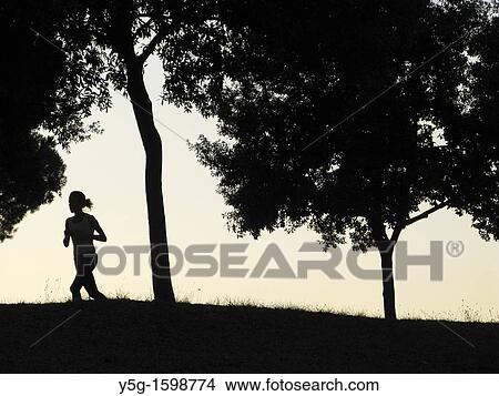 silhouette lonely runner in woods at dusk View Large Photo Image Picture - silhouette lonely runner in woods at dusk. Fotosearch