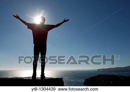 Silhouette of a male athlete by the sea reaching up to the sky View Large Photo Image Stock Photo - Silhouette of a male athlete by the sea reaching up to the sky. Fotosearch