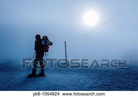 Picture - Silhouette of a mountaineer in a misty snowed winter landscape, Poland.. Fotosearch