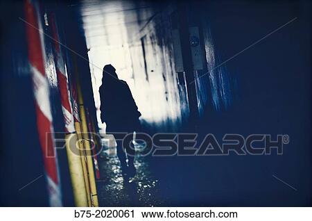Silhouette of a person moving through a passage in East London, England, UK View Large Photo Image Stock Image - Silhouette of a person moving through a passage in East London, England, UK. Fotosearch