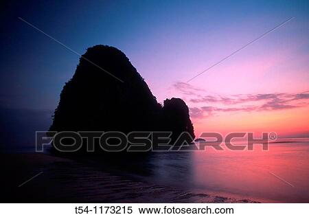 Stock Photography - Silhouette of a rock in the sea at sunset. Fotosearch