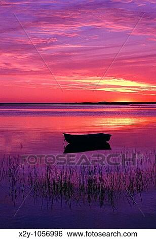 Stock Photograph - Silhouette of a row boat in harbor, Roberts Cove, East Orleans, Cape Cod, Massachusettes. Fotosearch