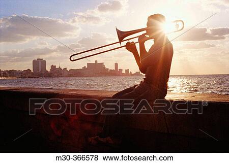 Silhouette of a trombone player on the Malec? n. Havana, Cuba View Large Photo Image Stock Photo - Silhouette of a trombone player on the Malec? n. Havana, Cuba. Fotosearch