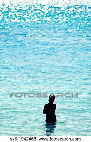Silhouette of a woman standing in the sea. View Large Photo Image Stock Photo - Silhouette of a woman standing in the sea.. Fotosearch