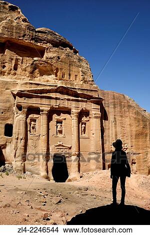 Picture - Silhouette of a woman watching the fa? ade of the Roman Soldier's Tomb, carved out of a sandstone rock face. Jordan (Hashemite Kingdom of), Ma'an Governorate (Maan), ancient city of Petra. Model Released.. Fotosearch