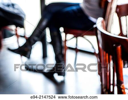 Silhouette of a woman's legs sitting on a chair in a restaurant. View Large Photo Image Picture - Silhouette of a woman's legs sitting on a chair in a restaurant.. Fotosearch