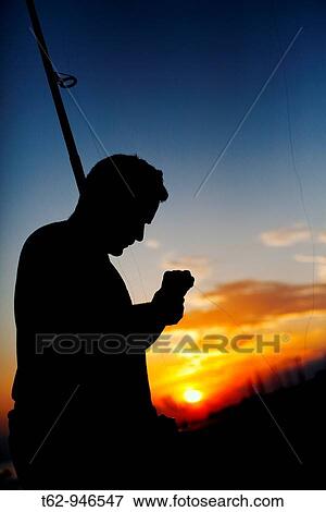 Silhouette of an angler preparing their fishing gear at sunset on the beach Mediterranean Sea View Large Photo Image Stock Photo - Silhouette of an angler preparing their fishing gear at sunset on the beach Mediterranean Sea. Fotosearch