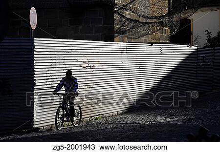 Silhouette of bicycle rider in front of metal fence in Jerez de la Frontera, Andalusia Spain. View Large Photo Image Stock Image - Silhouette of bicycle rider in front of metal fence in Jerez de la Frontera, Andalusia Spain.. Fotosearch