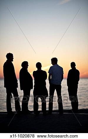 Silhouette of five men standing watching the sunset over Cardigan Bay from the promenade Aberystwth Wales UK View Large Photo Image Stock Photo - Silhouette of five men standing watching the sunset over Cardigan Bay from the promenade Aberystwth Wales UK. Fotosearch