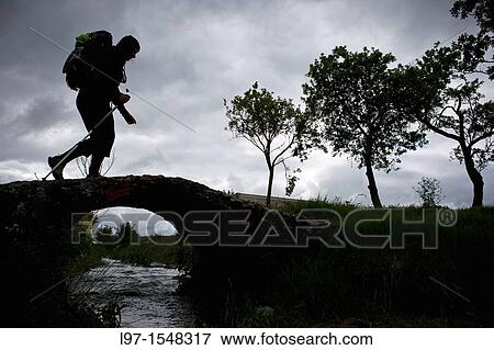 Silhouette of hiker crossing bridge along the Camino de Santiago, route Frances View Large Photo Image Stock Photo - Silhouette of hiker crossing bridge along the Camino de Santiago, route Frances. Fotosearch