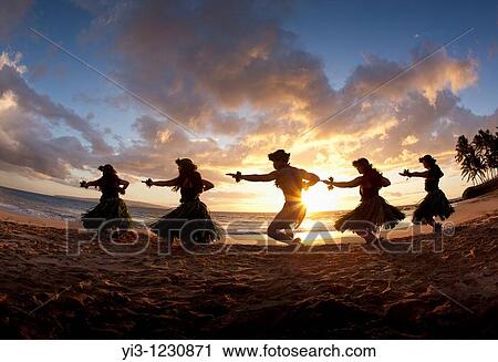 Stock Image - Silhouette of hula dancers at sunset at Palauea Beach, Maui, Hawaii. Fotosearch