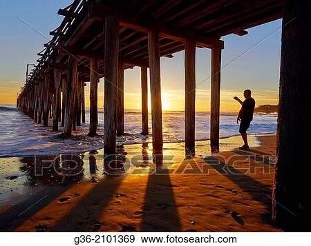 Stock Photo - Silhouette of man at beach during sunset in Cayucas, California, United States.. Fotosearch